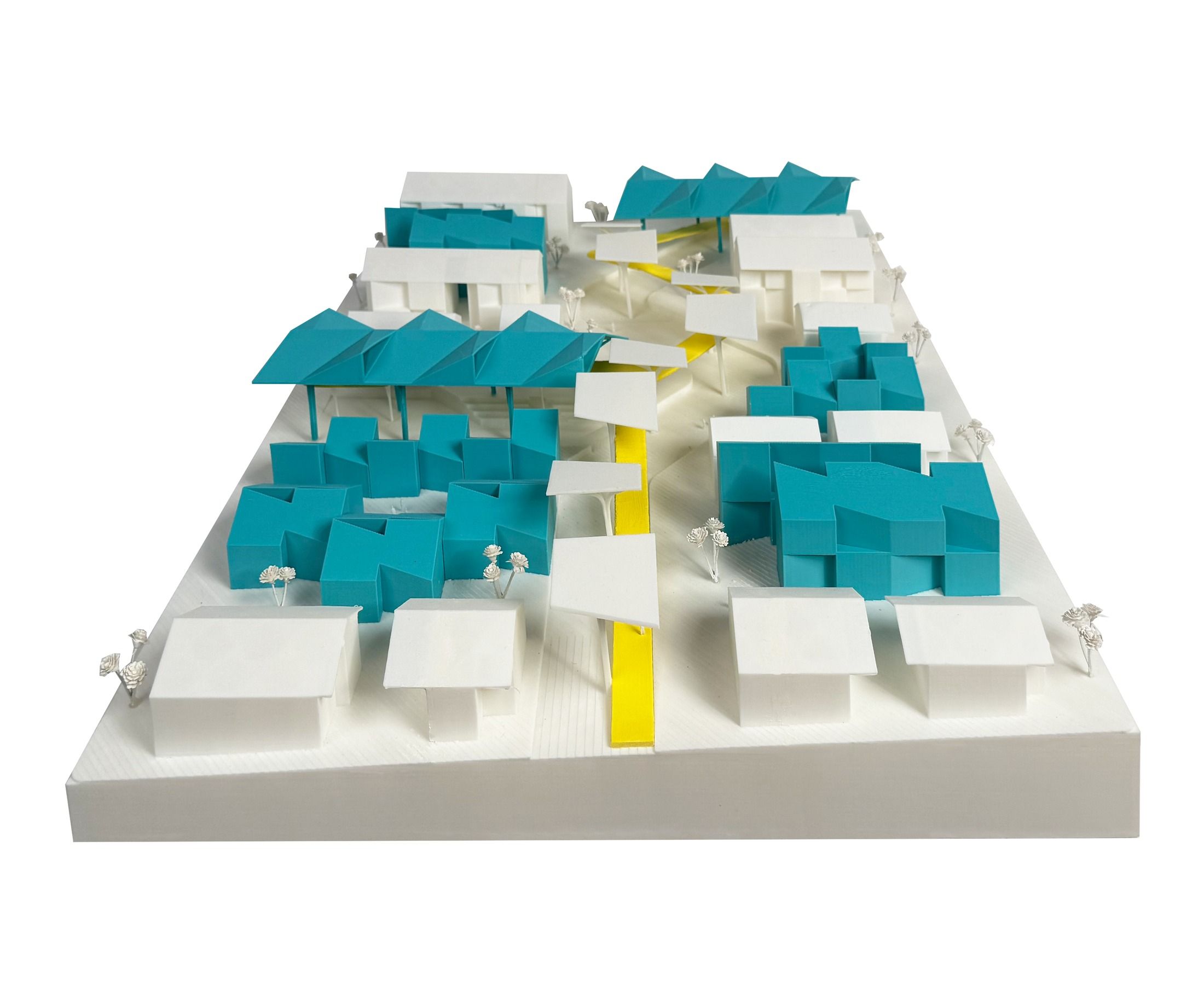 Physical model photograph, angled view of the modular housing cluster with teal accessory dwelling units along a yellow pathway