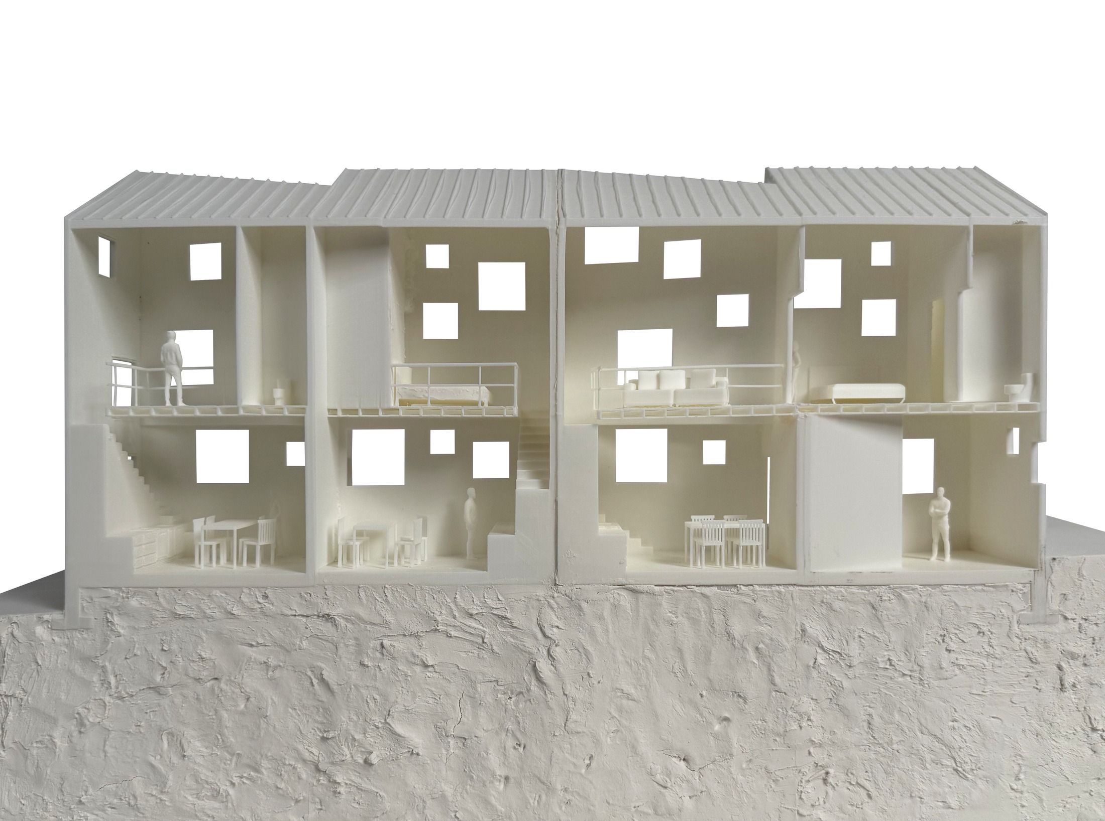 Physical model photograph, sectional view revealing interior rooms, furniture, and a rooftop terrace